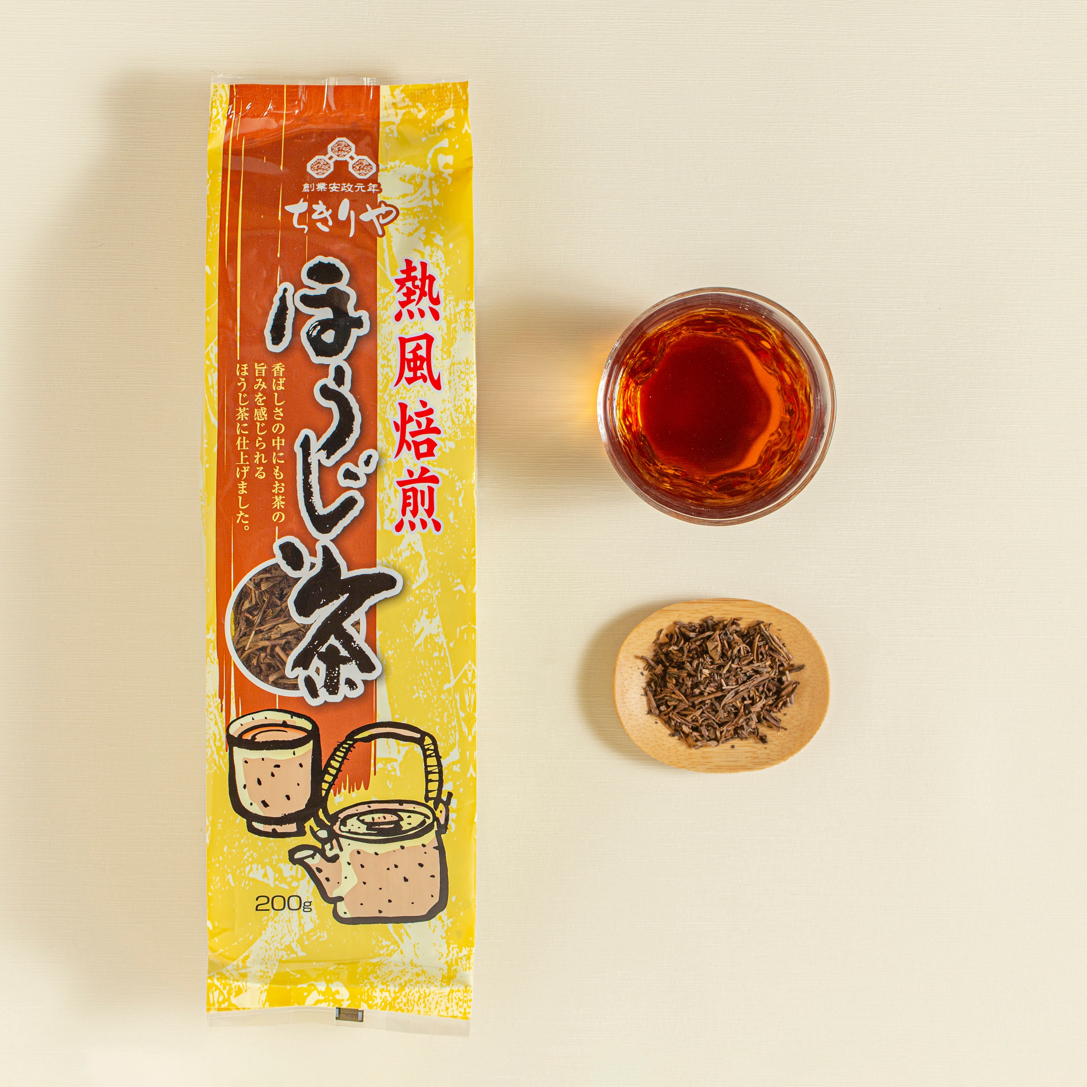 Tea package with a cup of tea and a saucer with tea leaves on a beige background