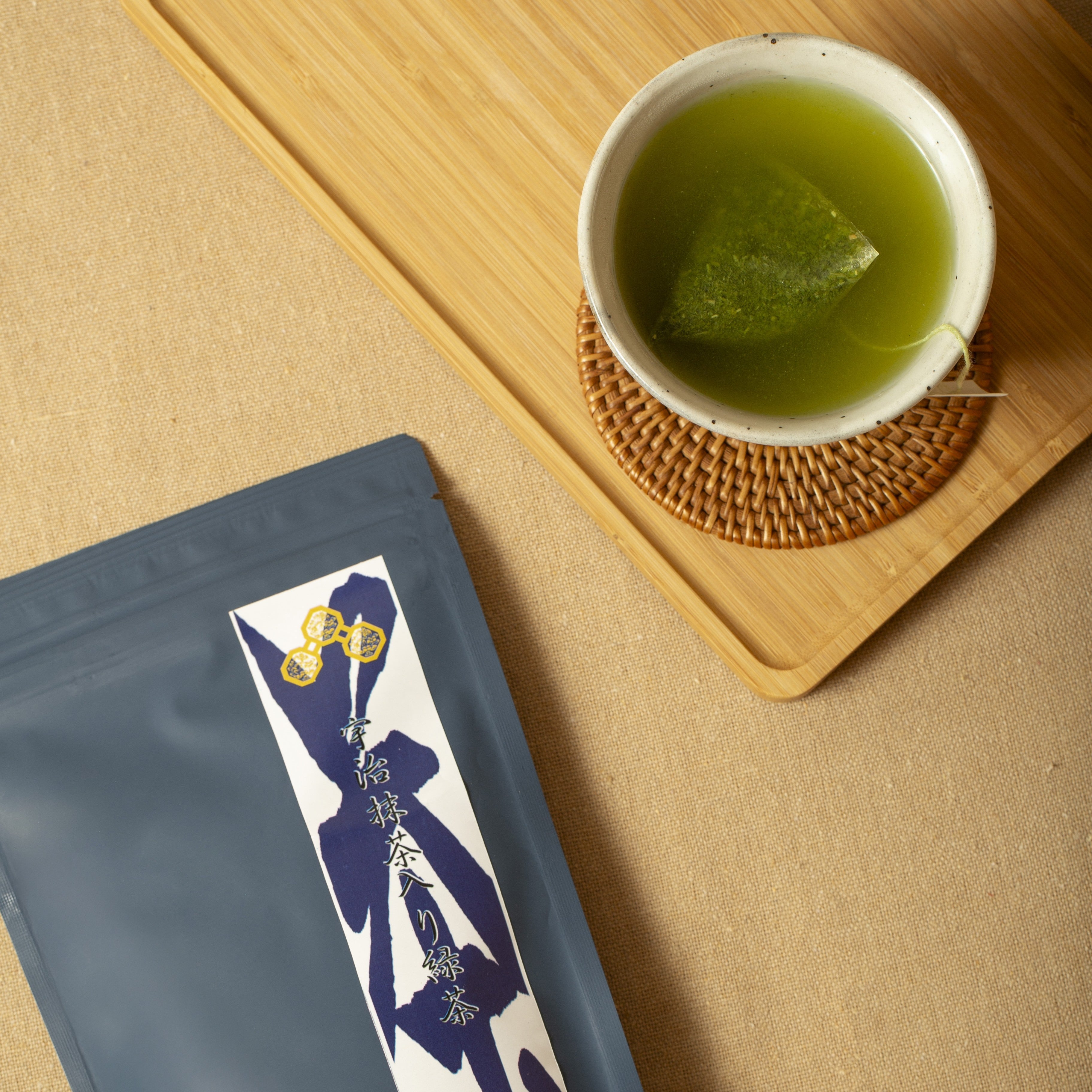 Tea cup with green tea and a tea bag on a wooden board
