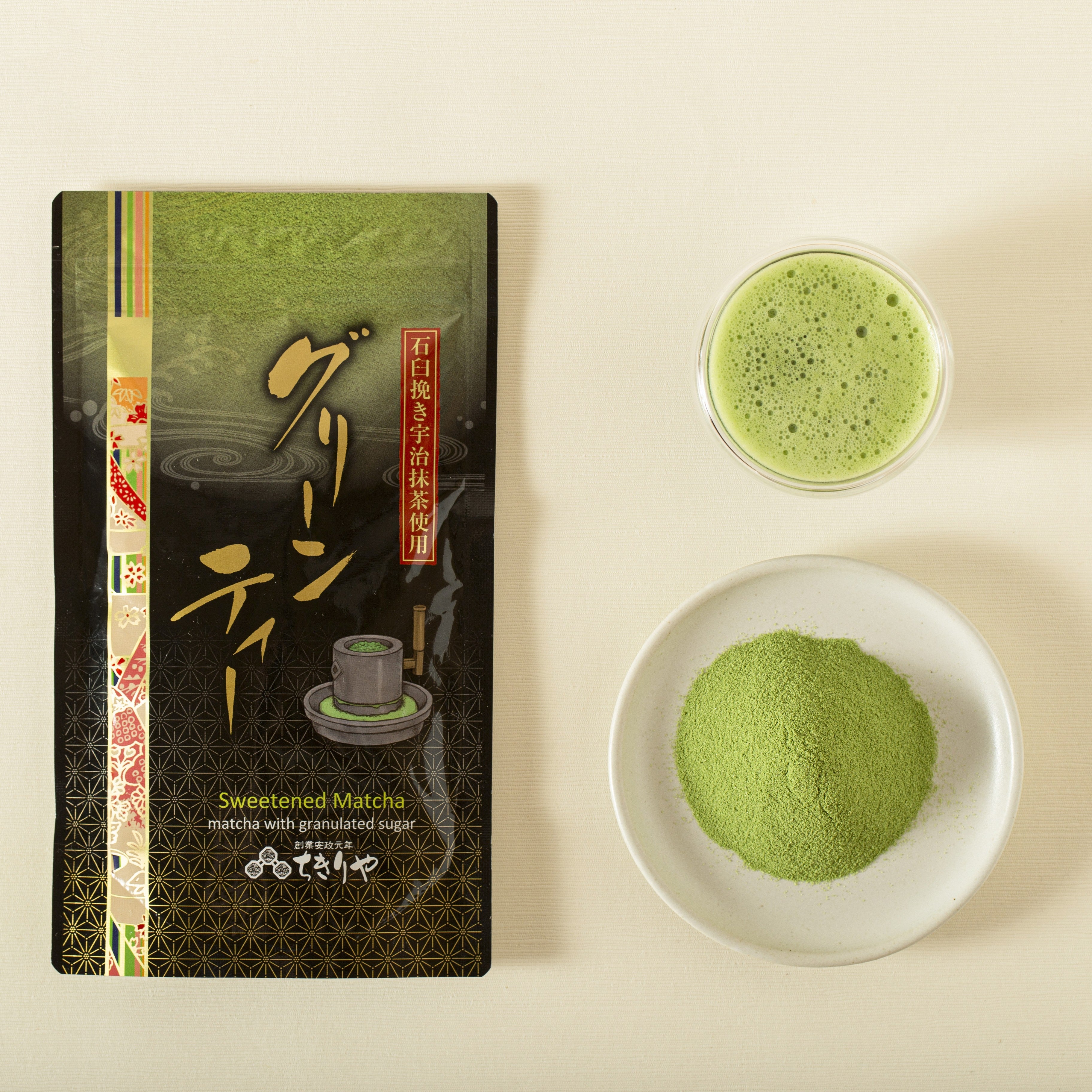 Matcha packaging with a bowl of matcha powder and a cup of matcha on a beige background