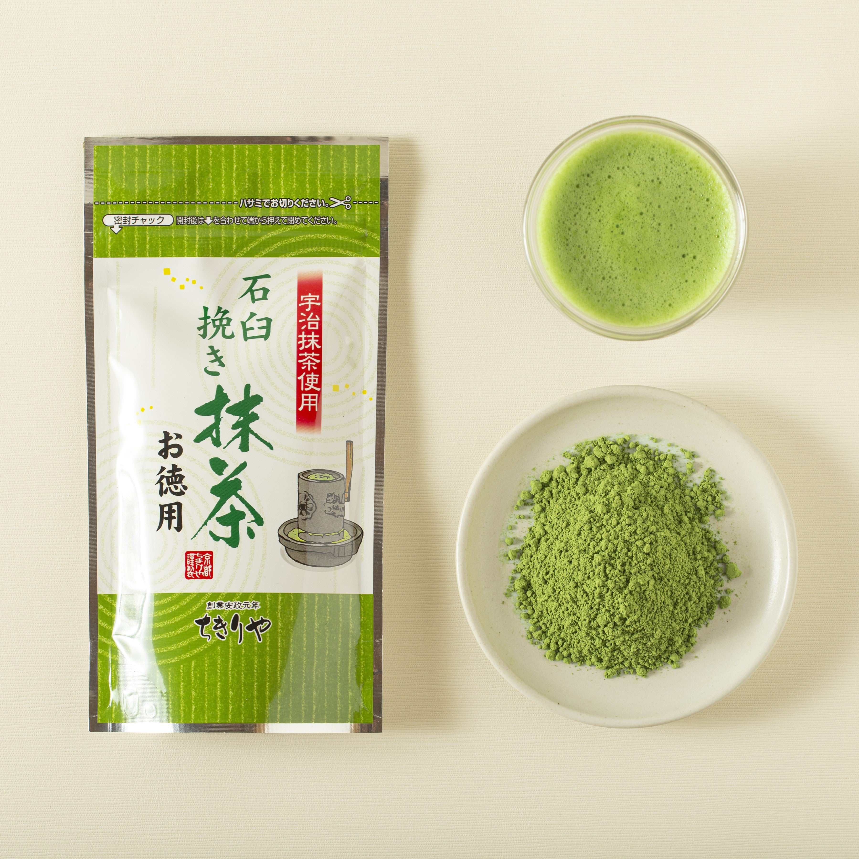 Matcha green tea package, bowl of matcha powder, and cup of matcha on a beige background