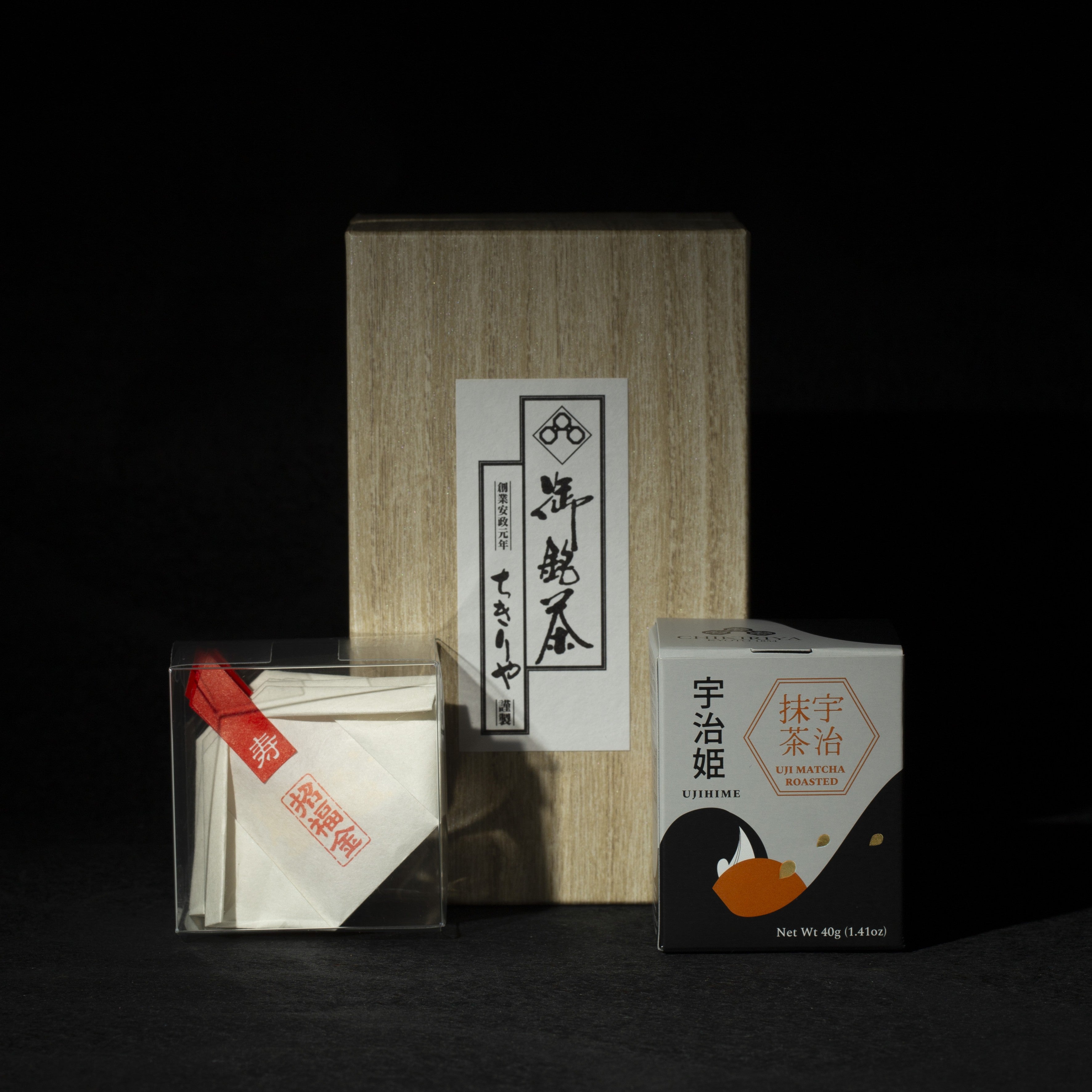 Tea packaging with a wooden box and transparent container with gold edible glitter flakes, matcha can on a dark background