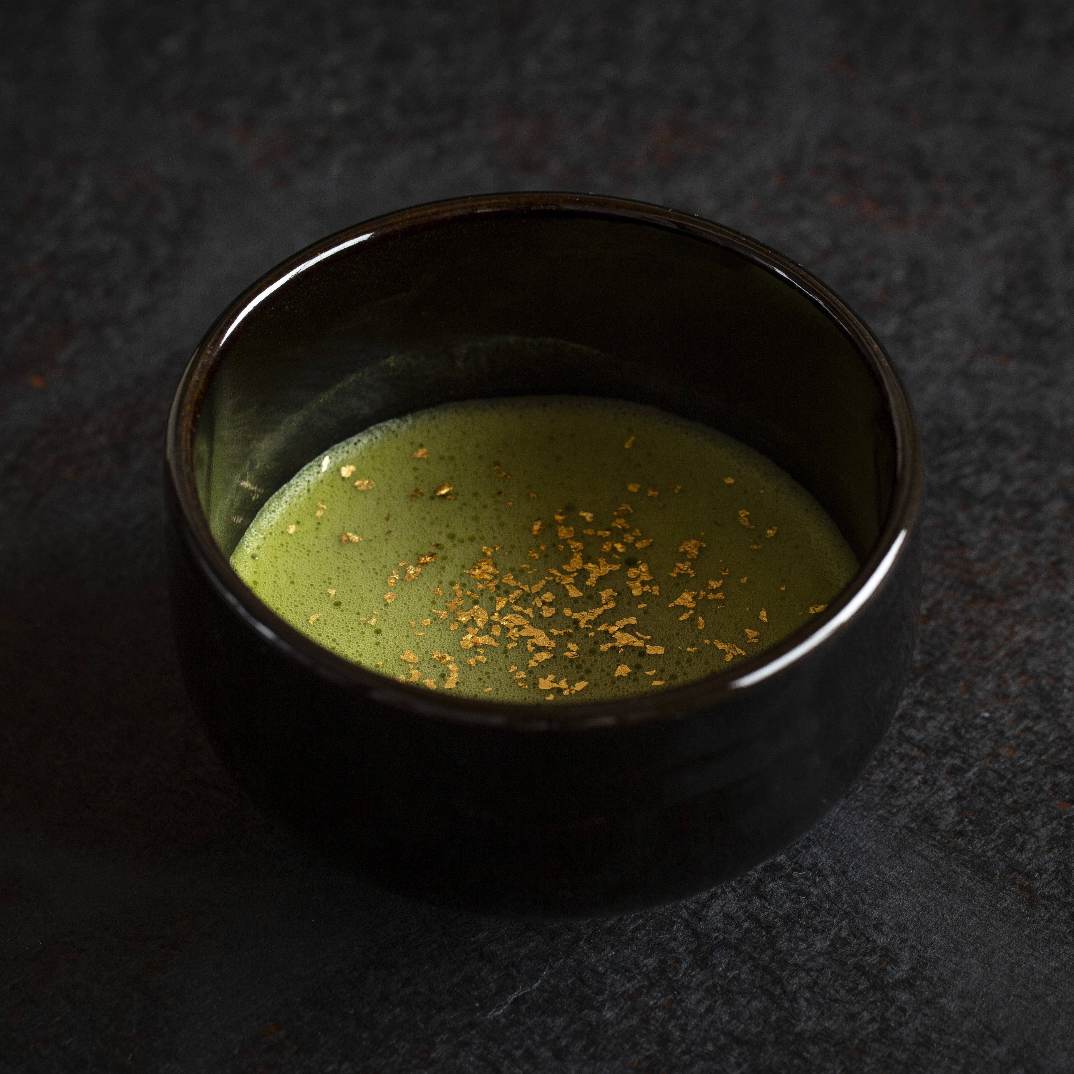 Black ceramic bowl with matcha and gild edible glitter flakes