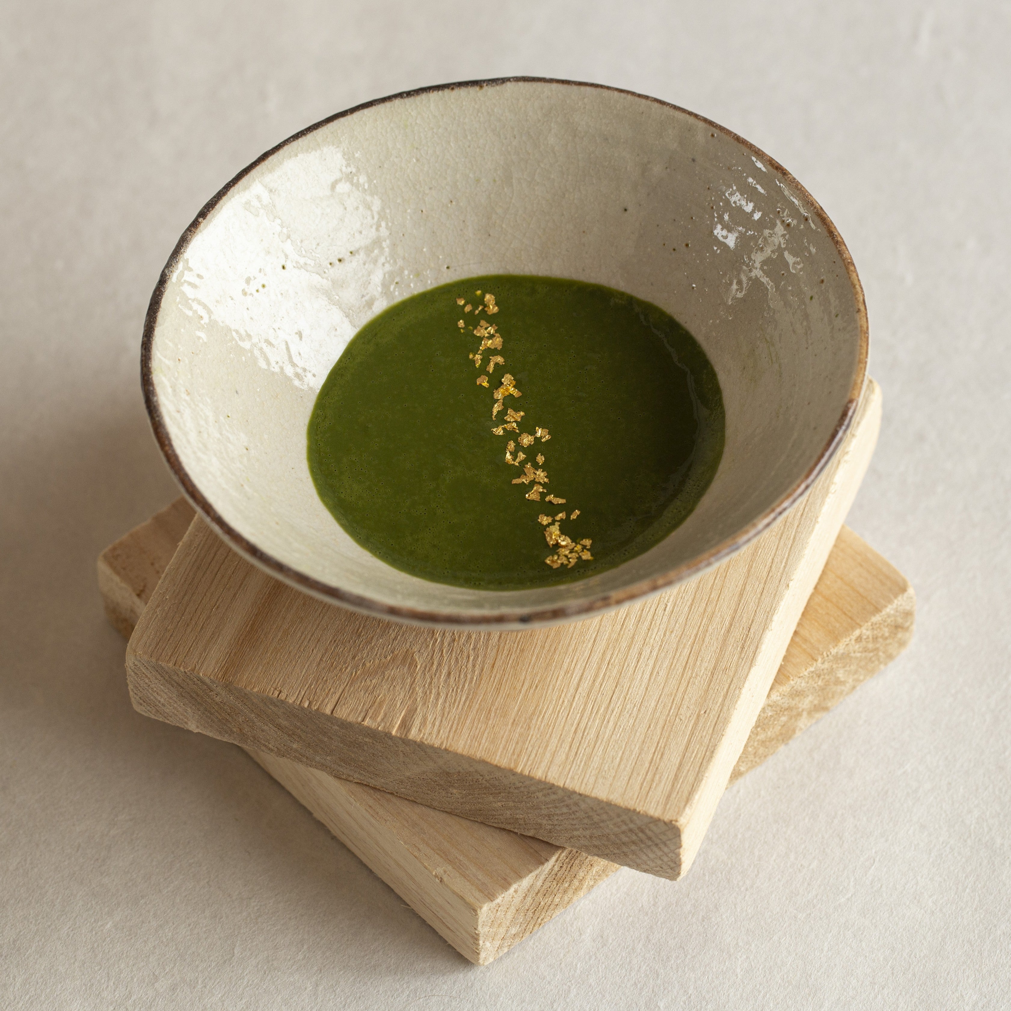 White ceramic bowl with matcha and gild edible glitter flakes