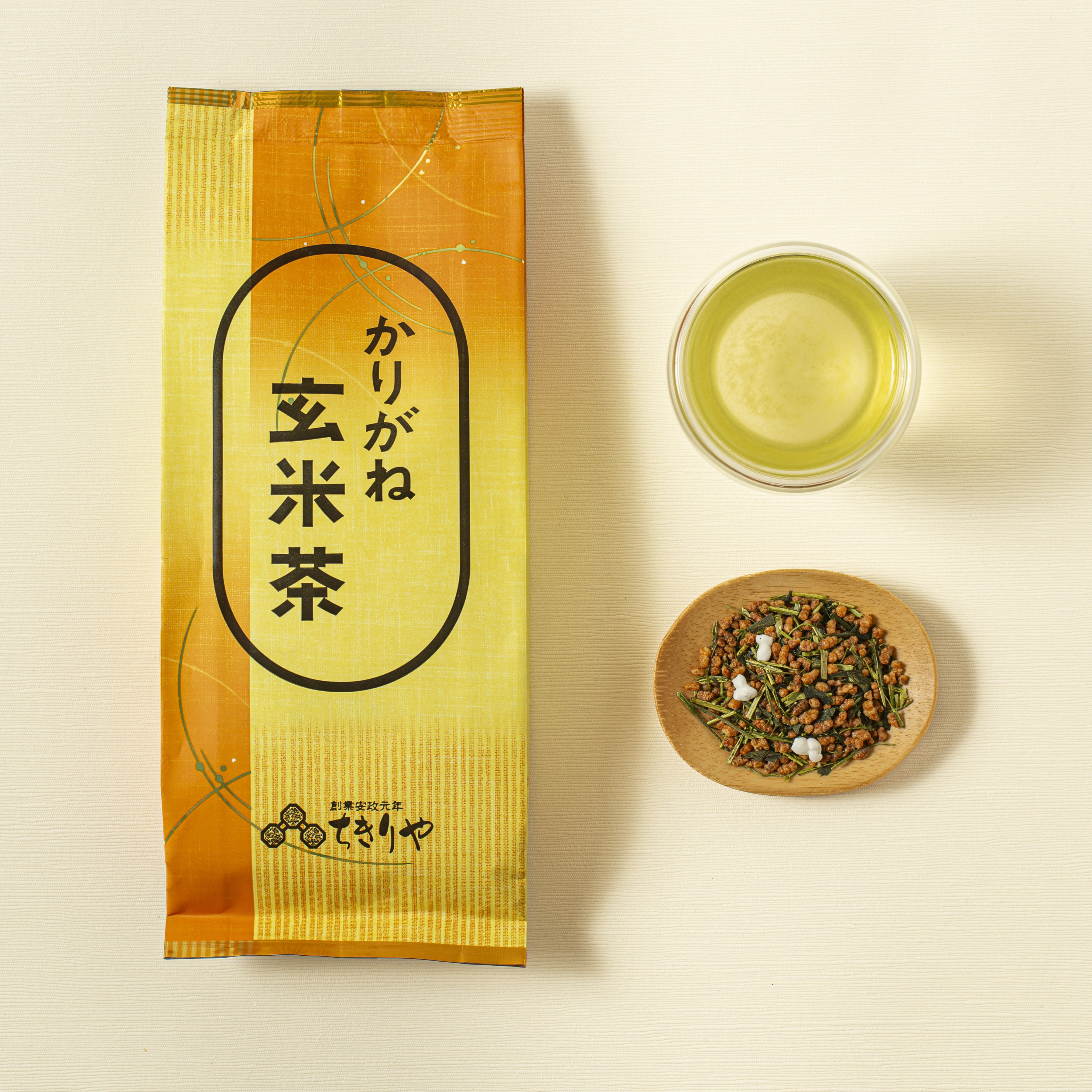 Tea package with a bowl of tea leaves and a cup of tea on a light background
