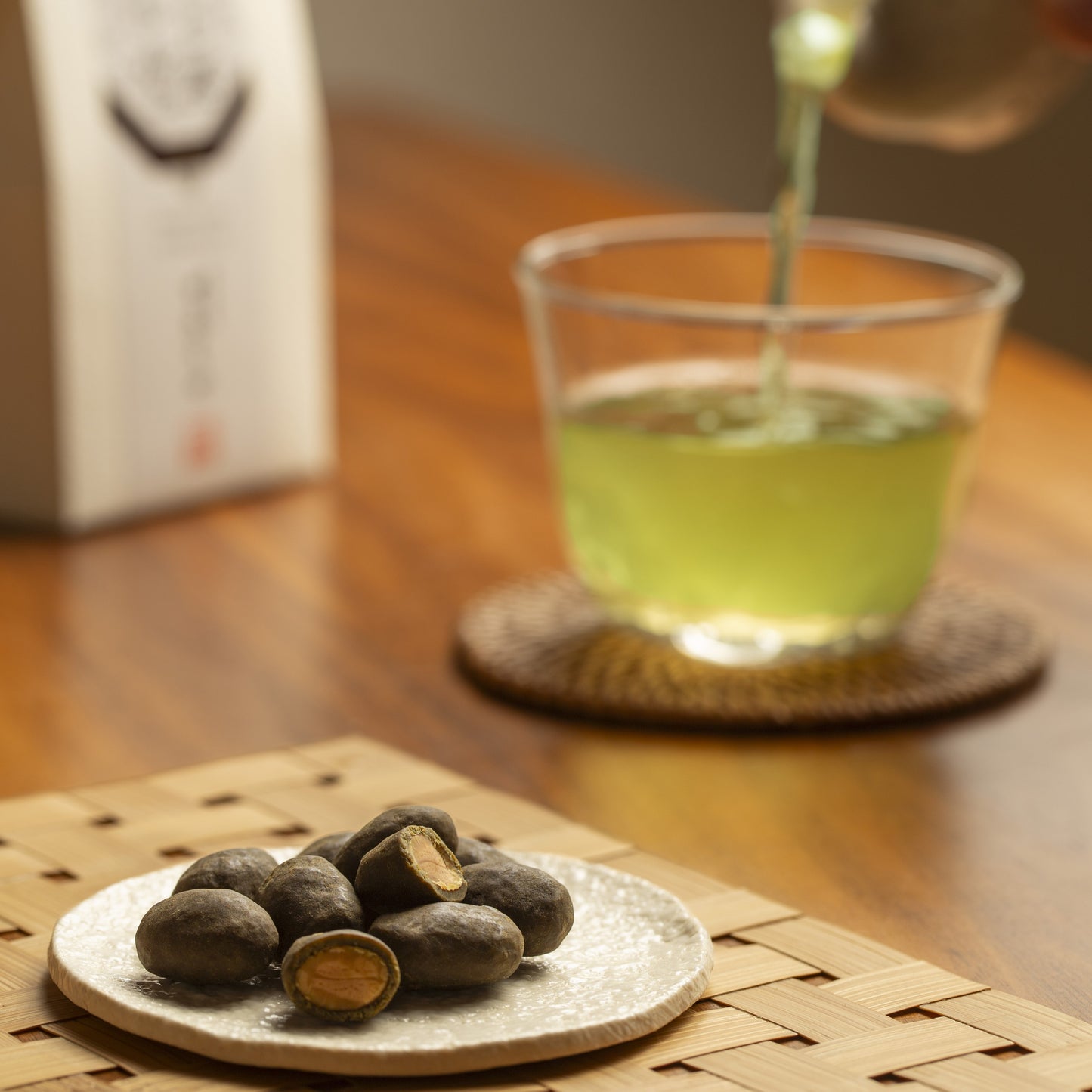 At first, some hojicha almonds with one in half, roasted almond with hojicha coating. In the back japanese green tea in a glass mug and almonds box