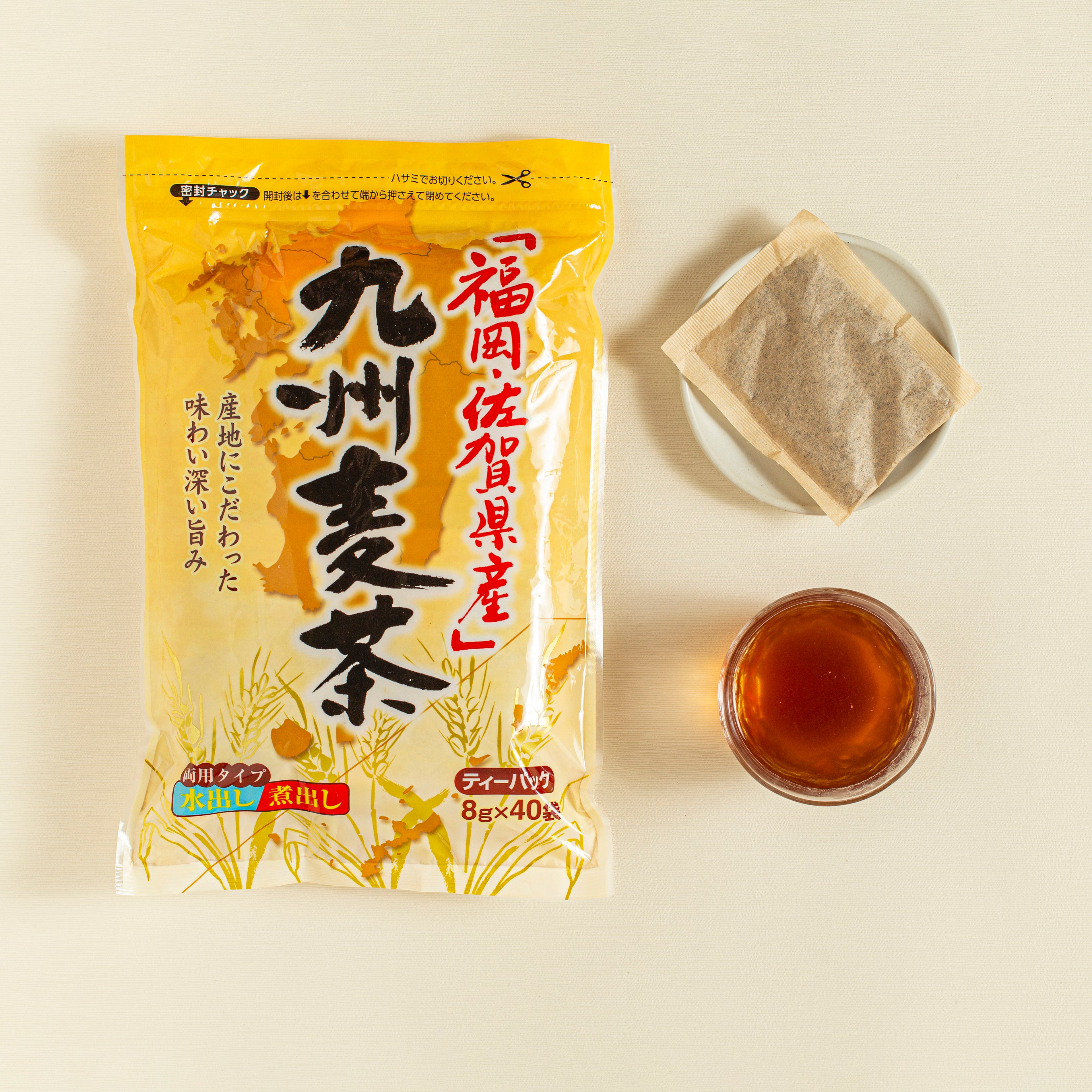 Tea package with tea bags and a cup of tea on a beige background