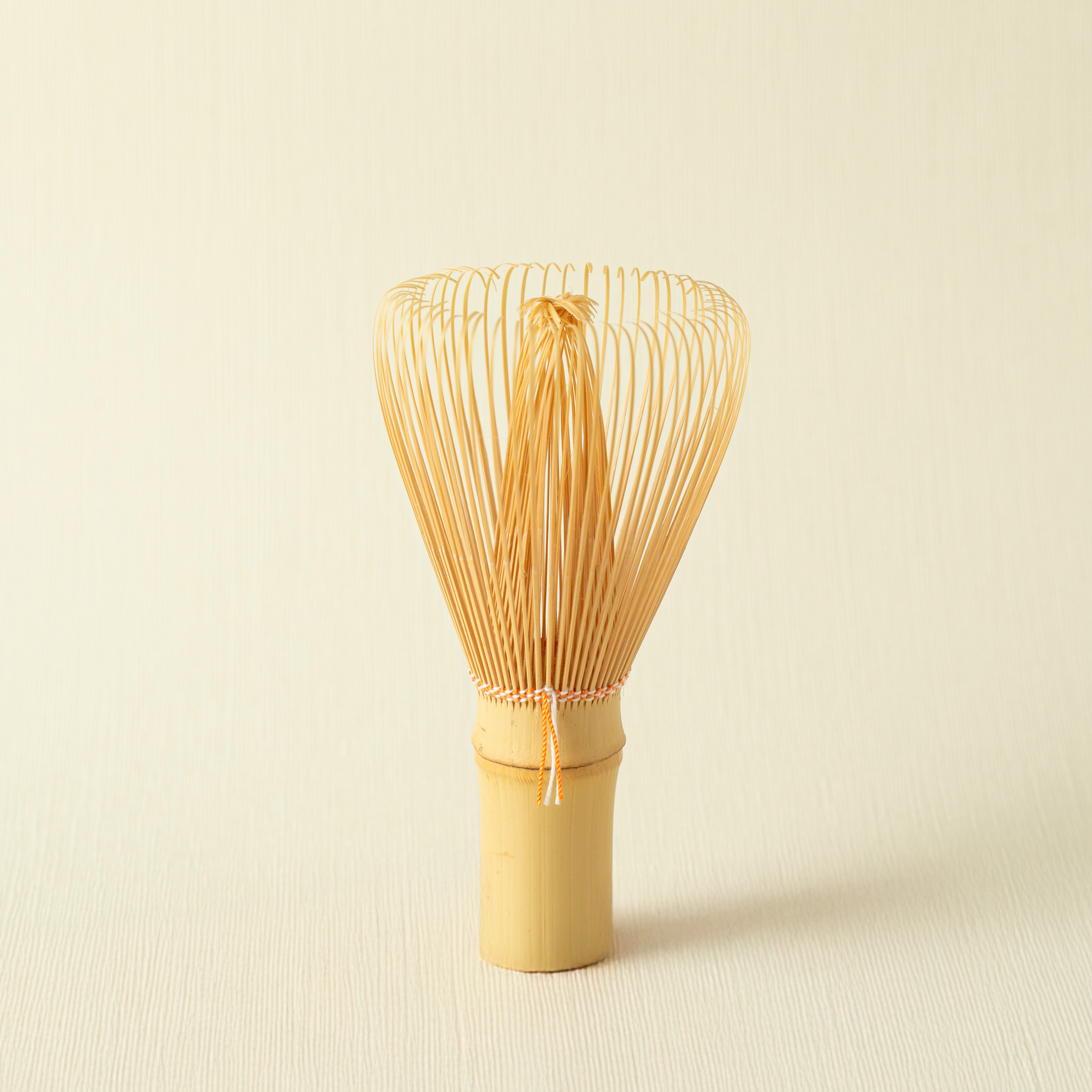 Bamboo whisk on a beige background