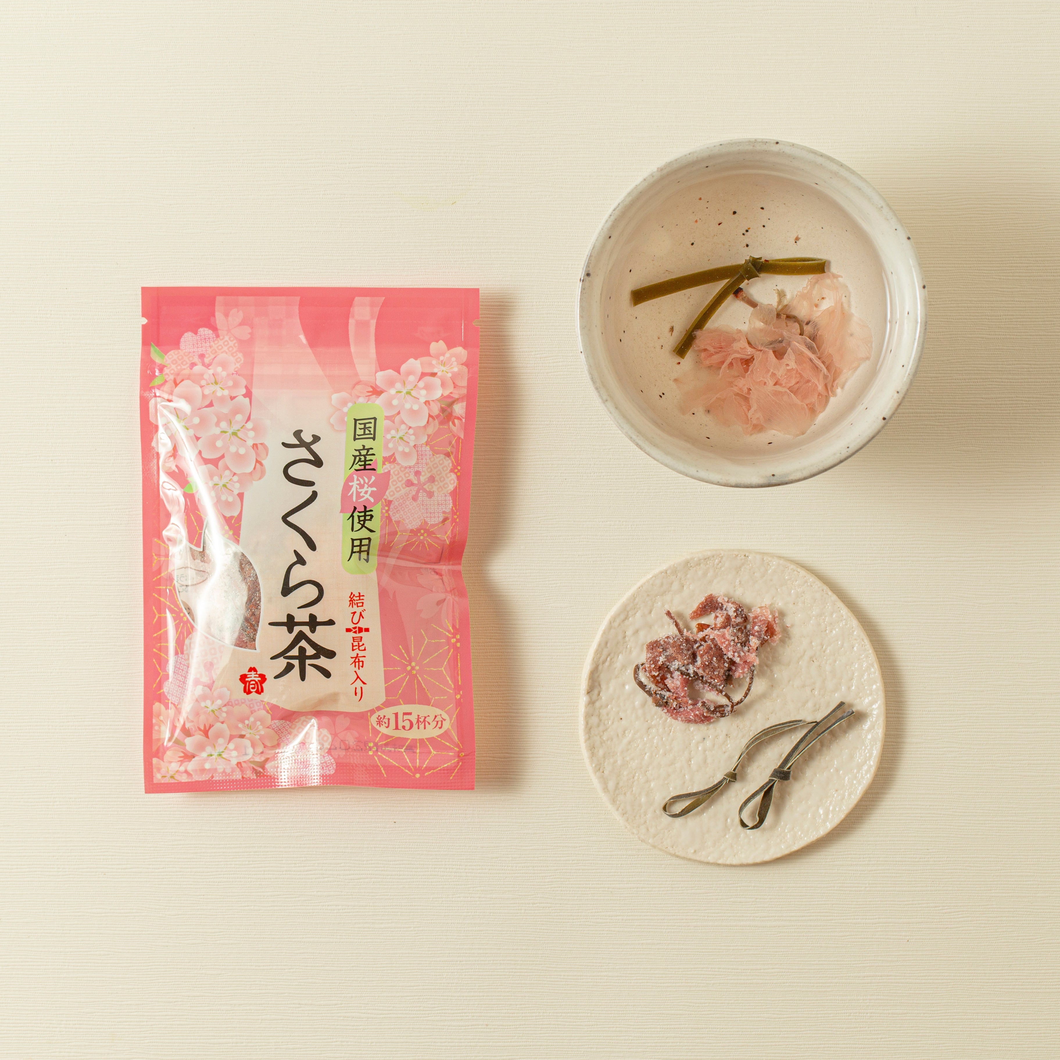 Pink tea package with a bowl of cherry blossom-themed tea on a beige background
