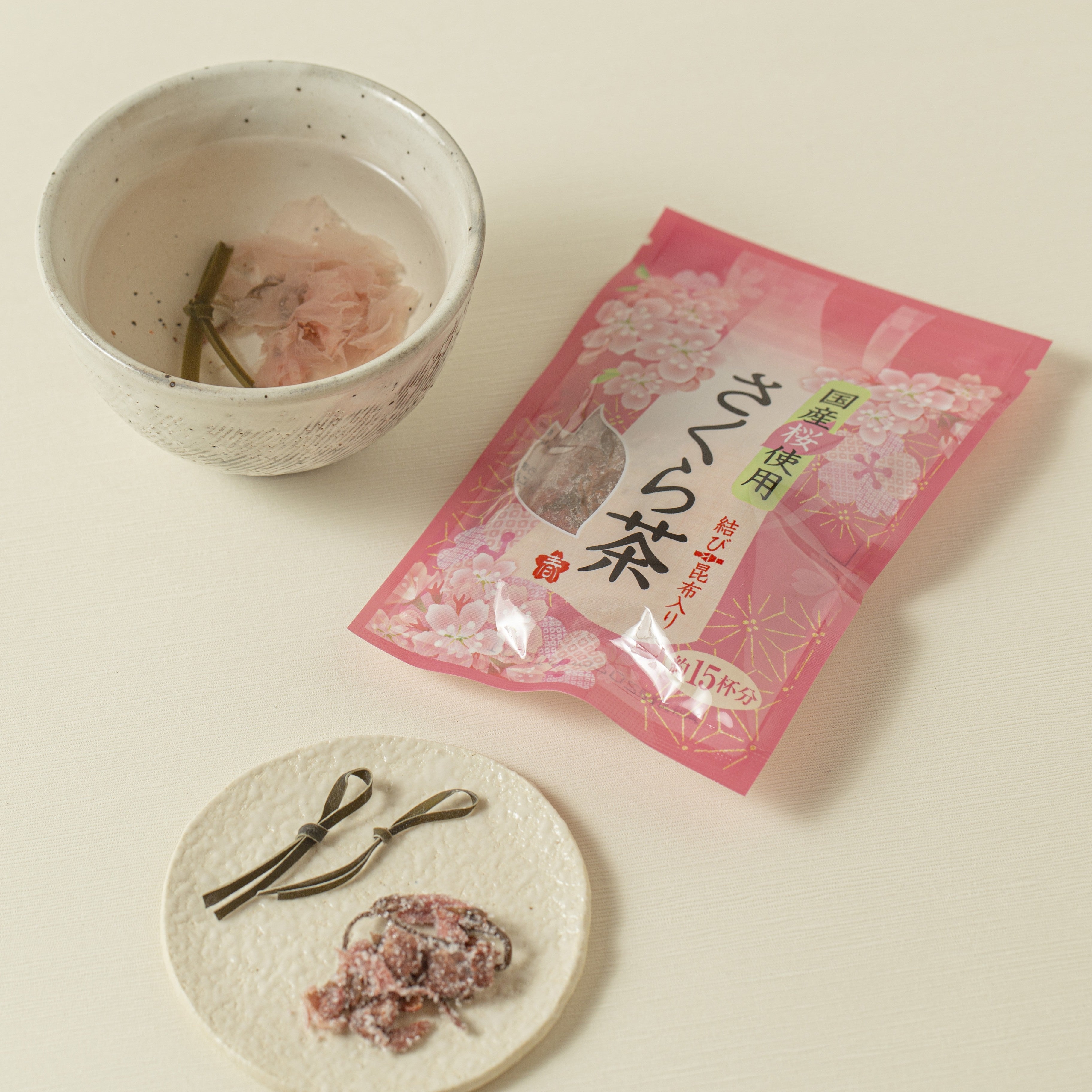 Tea package with a cup of tea and tea leaves on a light surface