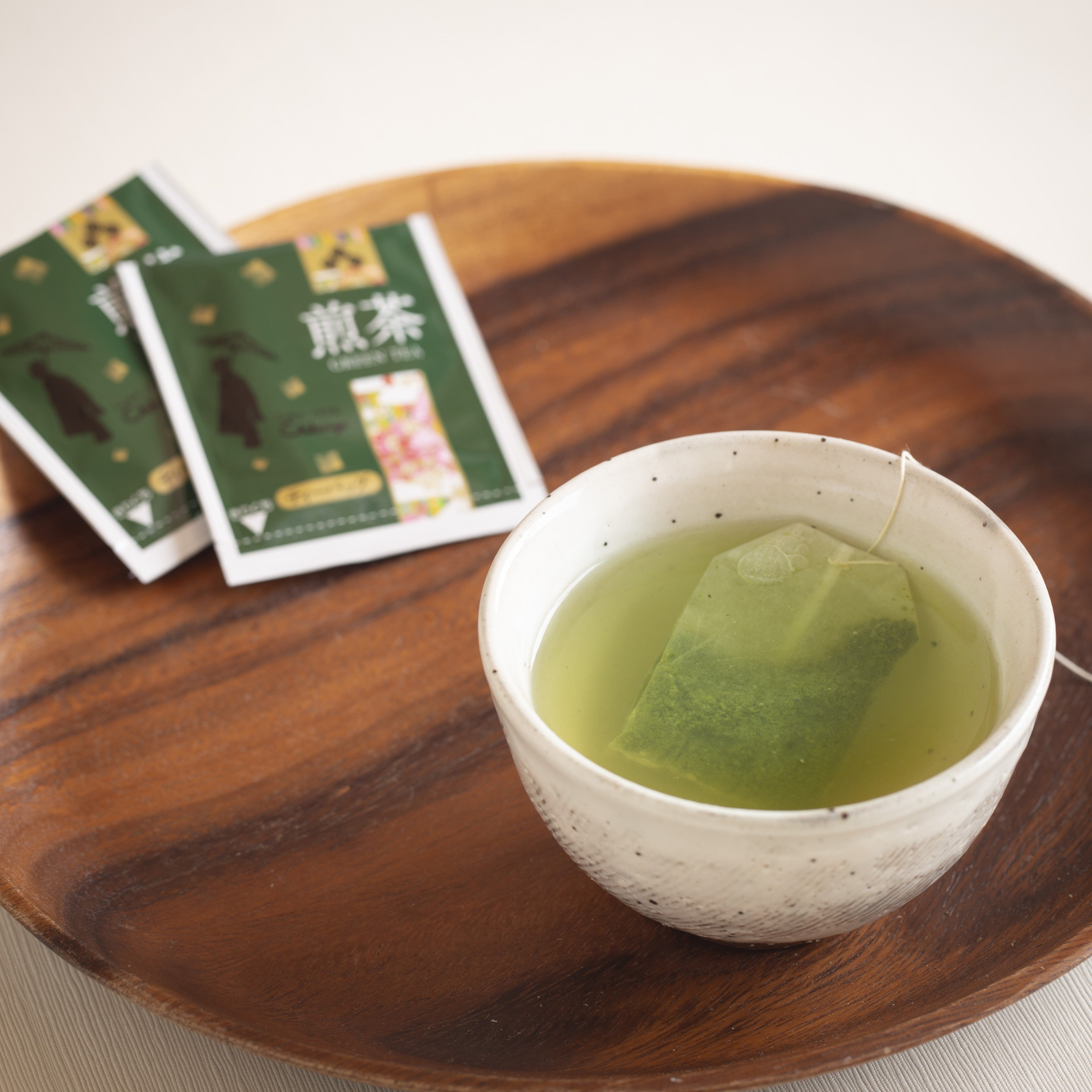 White ceramic cup with Sencha with Uji Matcha green tea and tea bags on a wooden surface
