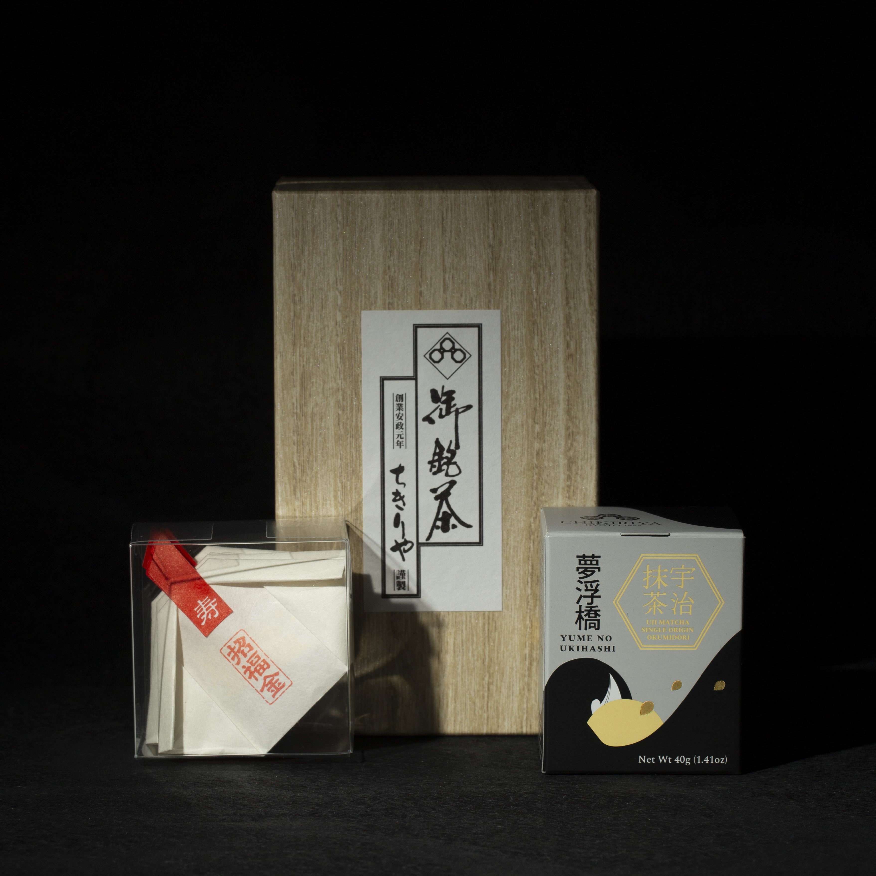 Tea packaging with a wooden box and transparent container with gold edible glitter flakes, matcha can on a dark background