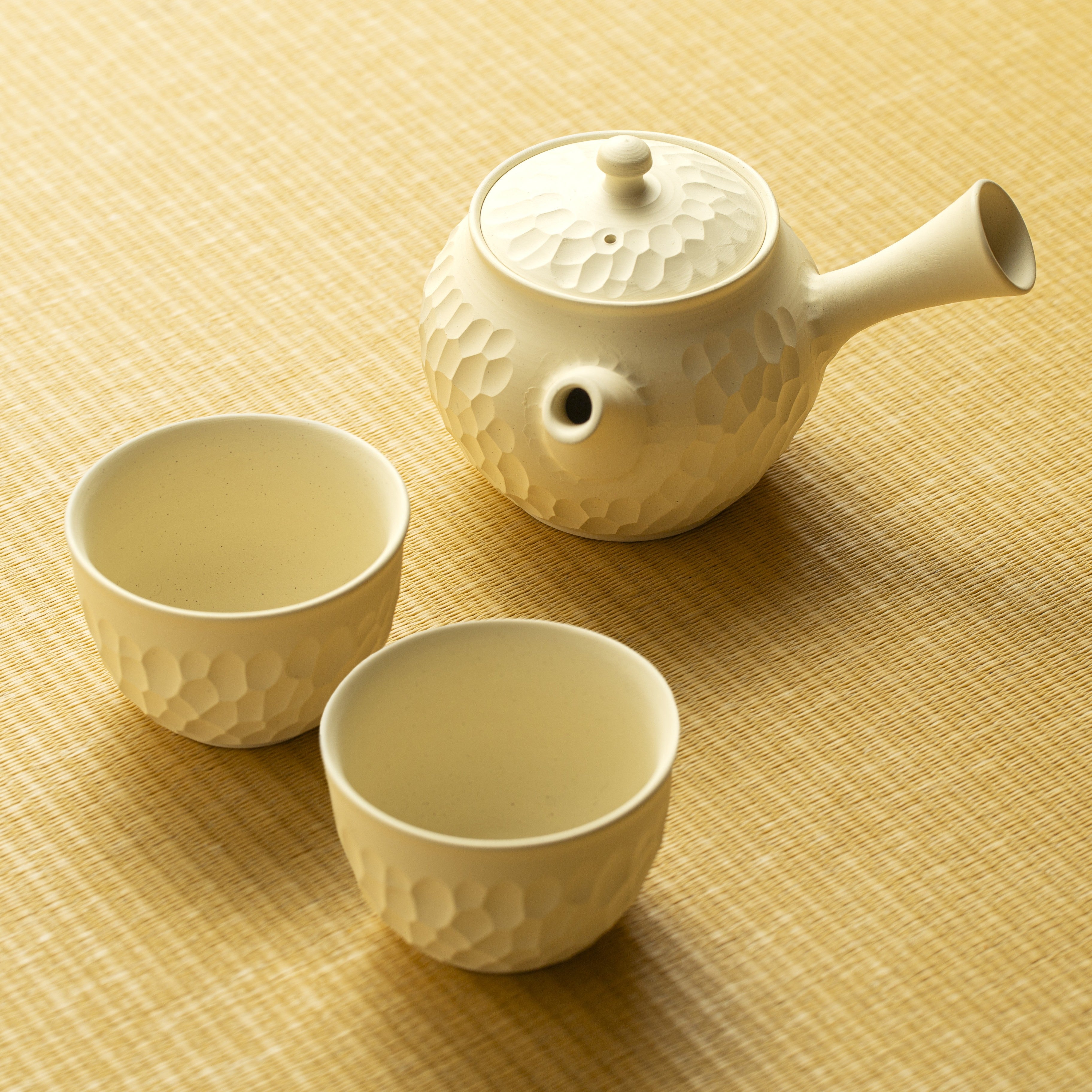 White ceramic teapot and two cups on a tatami