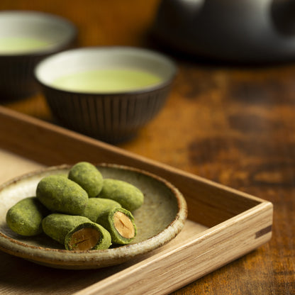 At first, some matcha almonds with one in half, roasted almond with matcha coating. In the back japanese green tea in a cup and kyusu teapot