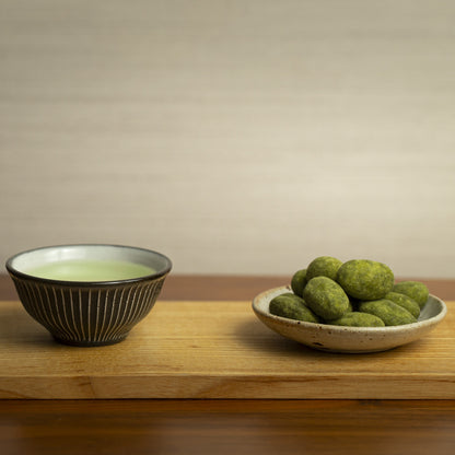 On left, japanese green tea. On right, matcha almonds in a plate