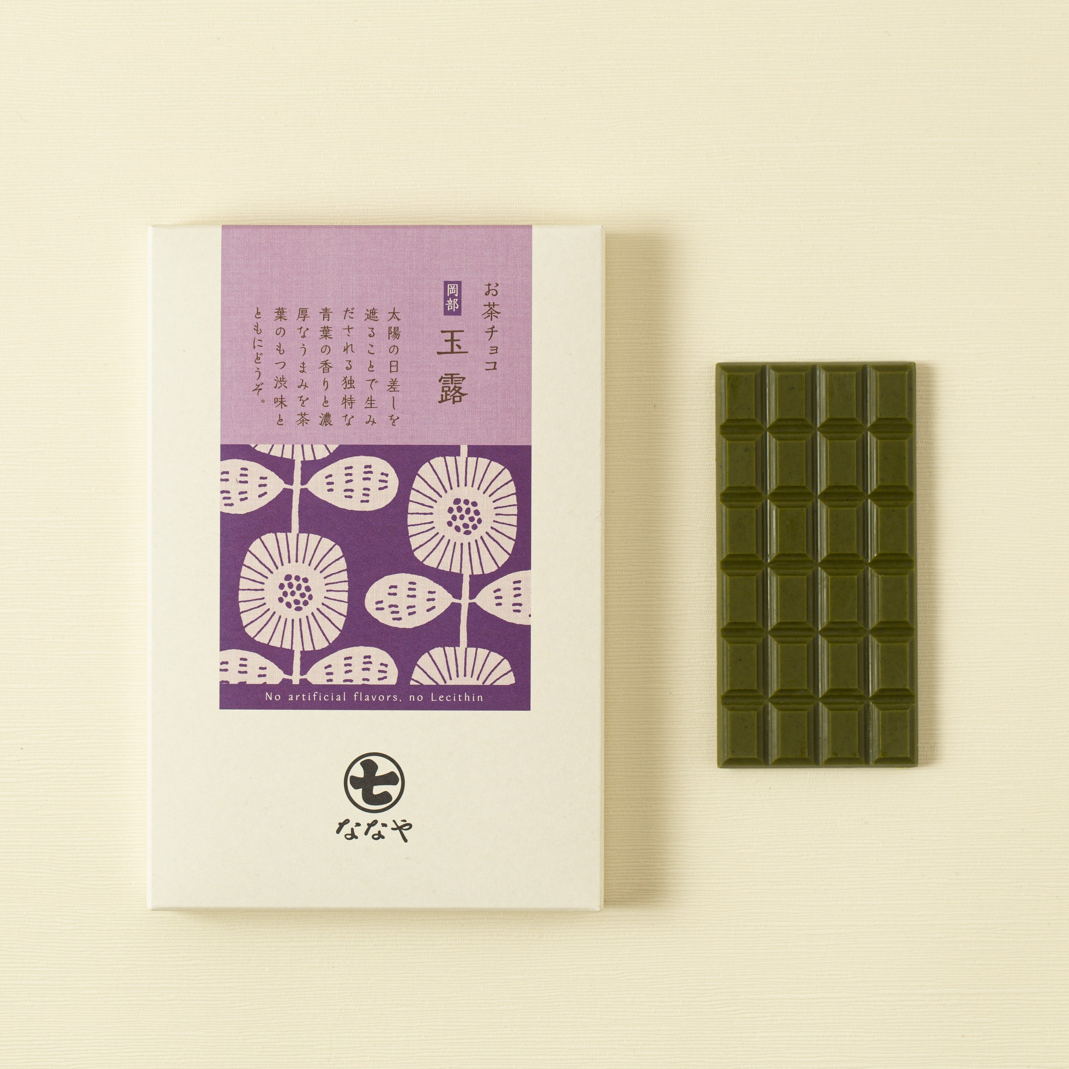 Green tea gyokuro chocolate bar next to its packaging with floral design on a beige background